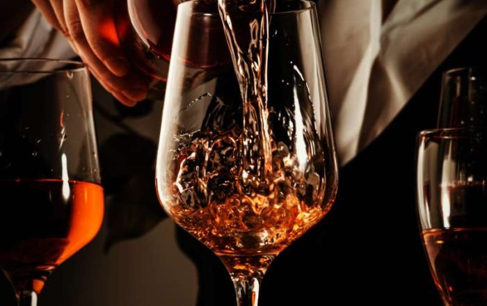 sommelier-pouring-rose-wine-into-glass-at-wine-tas